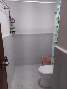 a bathroom with a toilet and a shower curtain at Saekyung 956 Condominium near SM seaside in Lo-oc