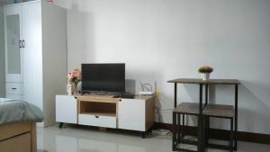 ein Wohnzimmer mit einem TV auf einem weißen Schrank in der Unterkunft Saekyung 956 Condominium in Lo-oc