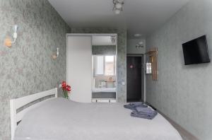1 dormitorio con cama, TV y baño en Бірюзова студія, Південний вокзал 5 хвилин en Járkov