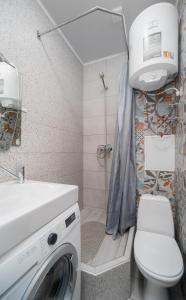 a bathroom with a washing machine and a toilet at Бірюзова студія, Південний вокзал 5 хвилин in Kharkiv