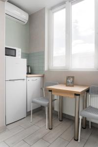 a kitchen with a table and chairs and a refrigerator at Бірюзова студія, Південний вокзал 5 хвилин in Kharkiv
