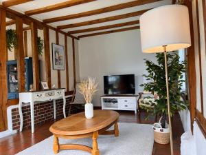 ein Wohnzimmer mit einem Tisch und einem TV in der Unterkunft Maison 110 m² cosy au calme avec jardin de 1000 m² in Pont-Audemer