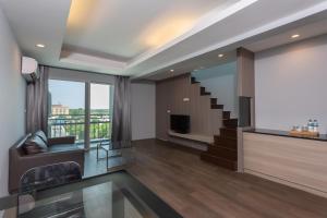 a living room with a staircase and a television at Tisha Hotel in Bang Bo