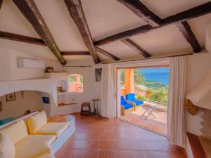 ein Wohnzimmer mit einem Sofa und einem großen Fenster in der Unterkunft Sardinia Family Villas - Villa Carmen with sea view and pool in Porto Cervo