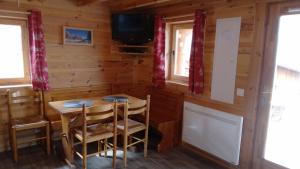 comedor en una cabaña de madera con mesa y sillas en La Plagne Chalet cosy calme proche valée, en La Plagne Tarentaise