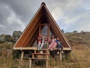 a group of children sitting in a triangular shaped house at mountain view willcacocha lodge in Huaraz