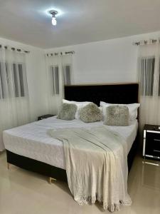- une chambre avec un grand lit et des oreillers dans l'établissement luxurious 3 bedroom apt w pool, à Santiago de los Caballeros
