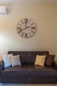 um grande relógio na parede acima de um sofá em Paradiso Esotico em Torre a Mare