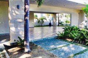 un hall d'une maison avec un palmier dans l'établissement luxurious 3 bedroom apt w pool, à Santiago de los Caballeros