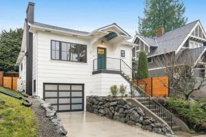 a white house with a garage at Perch - Emerald Cottage in Seattle
