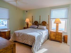 ein Schlafzimmer mit einem Bett mit zwei Lampen und zwei Fenstern in der Unterkunft Amazing Views! Bhw Lagoonfront Beauty! in Manahawkin