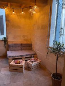 eine Terrasse mit einem Sofa, 2 Tischen und einem Baum in der Unterkunft Appartement à 10 min de St Rémy in Noves
