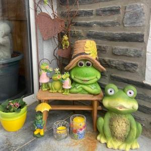 two frogs sitting on a chair with a hat at La Milardière in Theux