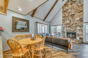 comedor con mesa y chimenea de piedra en Ruidoso Family Cabin, Short Walk to Downtown!, en Ruidoso