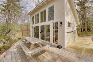 a house with a picnic table on a wooden deck at Beachfront Lake Michigan Cottage with Fire Pit and Deck in Muskegon