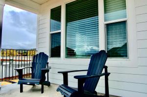 zwei blaue Stühle auf der Veranda eines Hauses in der Unterkunft Bear Lake Meadow View in Garden City