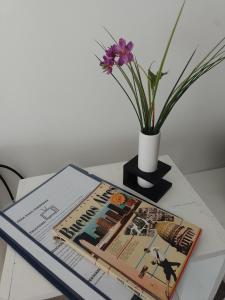 una revista en una mesa junto a un jarrón con una flor en Relax en Palermo con wifi 300MB y vista abierta en Buenos Aires