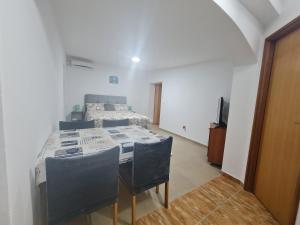 Habitación con cama, mesa y sillas. en Apartmani Jadro en Vir