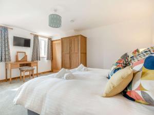 a bedroom with a white bed and a desk at 3 Bed in Newquay 89943 in Mawgan Porth