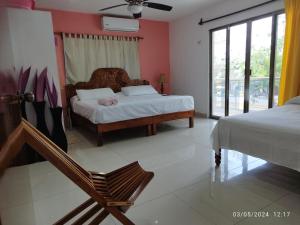 1 dormitorio con 2 camas y ventana en Casa Gacela Cozumel en Cozumel