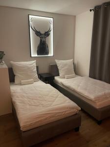 two beds in a room with a picture of a deer on the wall at Yellow&Black NEU Designer Apartment Bielefeld City WLAN kostenloser Parkplatz in Bielefeld