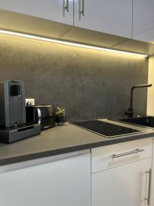 a kitchen counter with a stove and a microwave at Yellow&Black NEU Designer Apartment Bielefeld City WLAN kostenloser Parkplatz in Bielefeld