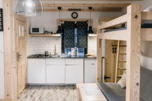 eine Küche mit weißen Schränken und einem Hochbett in der Unterkunft Ośrodek na zakręcie in Ustrzyki Dolne