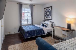 um quarto com uma cama, uma secretária, uma cama e uma janela em Spacious 3B Oasis near Manhattan - 28 mins to NYC em Jersey City