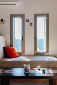 um quarto com duas janelas e uma cama com uma mesa em Villa Dioni em Ayios Nikitas
