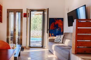 a living room with a couch and a tv at Villa Dioni in Agios Nikitas