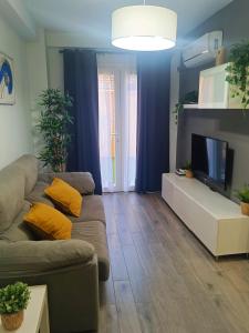 a living room with a couch and a flat screen tv at BEACH&GARDEN in Málaga +37 photos
