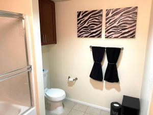 een badkamer met een toilet en handdoeken aan de muur bij The Downtown Suite in Los Angeles