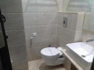 a bathroom with a toilet and a sink at Hotel Chanchal Continental in New Delhi