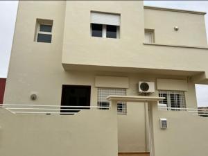 duży biały dom z w obiekcie Villa avec piscine privée w mieście Al-Dżadida