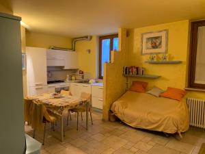 a bedroom with a bed and a table and a kitchen at Rosemary 2 in Fano