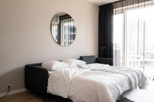 a bedroom with a bed with a mirror and a window at The Pier apartments by Daniel&Jacob's in Copenhagen