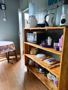 une cuisine avec des étagères en bois remplies de vaisselle dans l'établissement Wrech House Sagana -1989, à Sagana