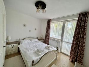 1 dormitorio con cama blanca y ventana en Apartament Central, en Vişeu de Sus