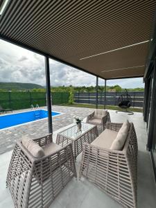 a patio with chairs and a table and a pool at Terra Solis Bihać Villa 1 in Bihać