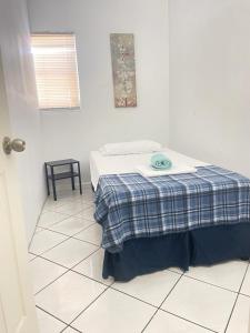 um quarto branco com uma cama com um cobertor azul em Mokulele em Miami