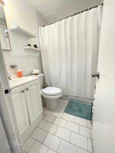 uma casa de banho branca com um WC e um chuveiro em Mokulele em Miami