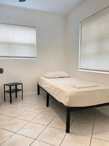 uma cama num quarto branco com uma janela em Mokulele em Miami
