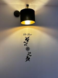 a lamp with a black design on a wall at Apartamenty Borysek De Lux in Białka Tatrzańska