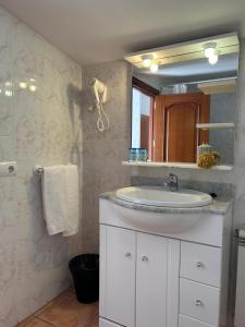a bathroom with a white sink and a mirror at Hotel Can Pepin in Cadaqués
