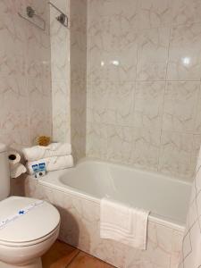 a bathroom with a white tub and a toilet at Hotel Can Pepin in Cadaqués