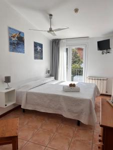 - une chambre blanche avec un grand lit et une fenêtre dans l'établissement Hotel Can Pepin, à Cadaqués