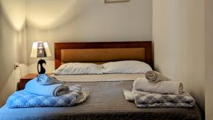 第比利斯Maximilian Apartment的一间卧室，床上有一张带毛巾的床