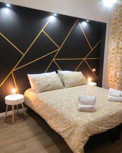 Schlafzimmer mit einem Bett mit einem schwarzen und goldenen Kopfteil in der Unterkunft A casa di Serena in Ancona