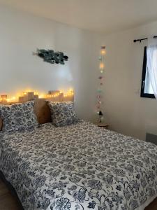 a bedroom with a bed with a black and white comforter at LE REFUGE DE LA BAIE in Beaussais sur Mer