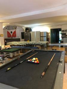una mesa de billar con dos cuesticks y bolas en ella en Zebulo Hostel en Panamá